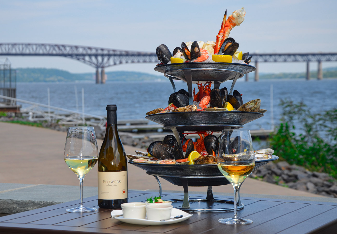 Photo of the Signature Shellfish Tower with lobster, clams, mussels, oysters, and wine on our outdoor patio overlooking the Newburgh Beacon Bridge